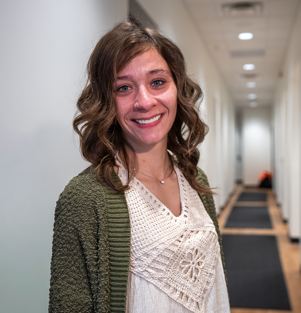 doctor Blair's all-on-x patient smiling in the office hallway